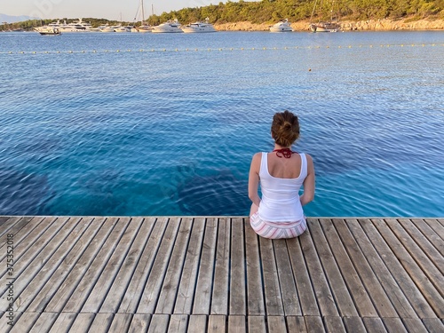 woman sitting wooden floor on the sea