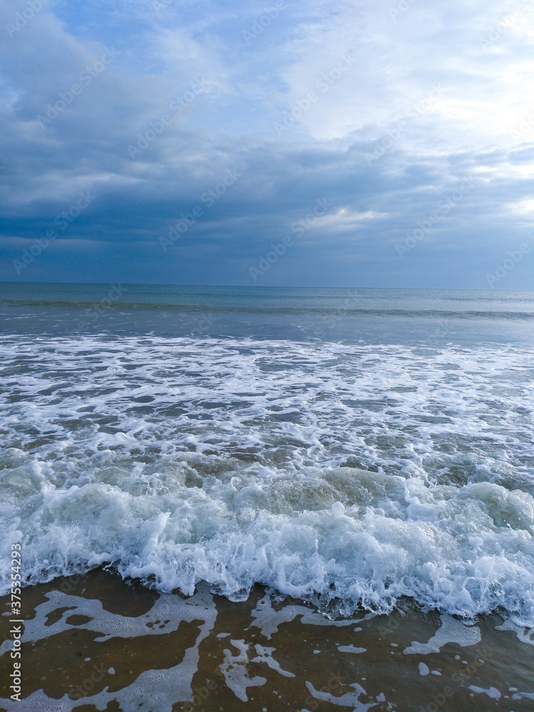 Anochecer en la playa con nubes azuladas.