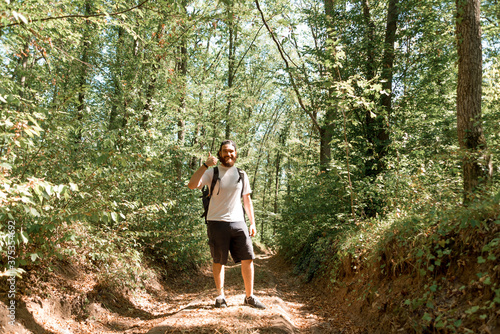 Portrait of cheerful bearded hiker man with backpack showing thu