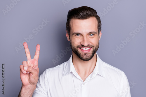 Close-up portrait of his he nice attractive content cheerful cheery brunet guy executive director employee sales manager colleague it expert showing v-sign isolated over gray pastel color background