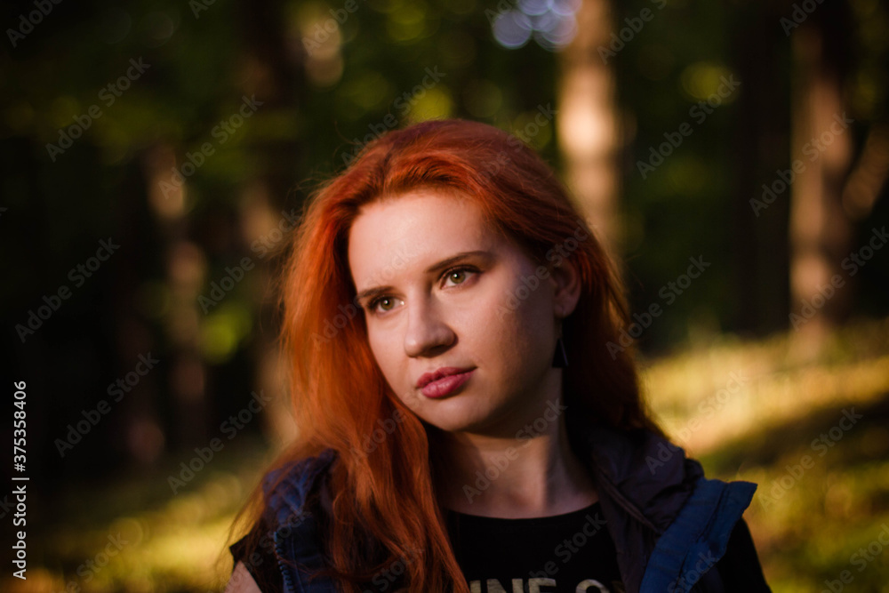 portrait of a young red-haired girl in the park portrait of a young red-haired girl in the park
