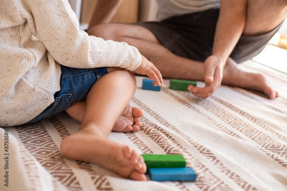 kid and his father playing at home with wood building blocks. Homeschooling. Stay at home. Family time kid and his father playing at home with wood building blocks. Homeschooling. Stay at home. Family time
