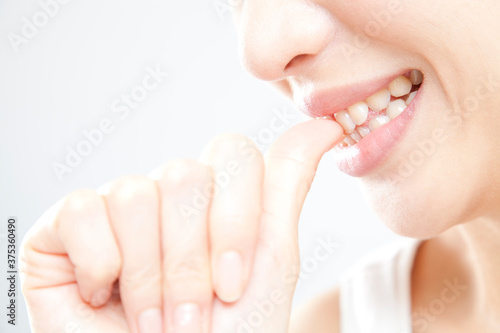 爪を噛む女性の手元
