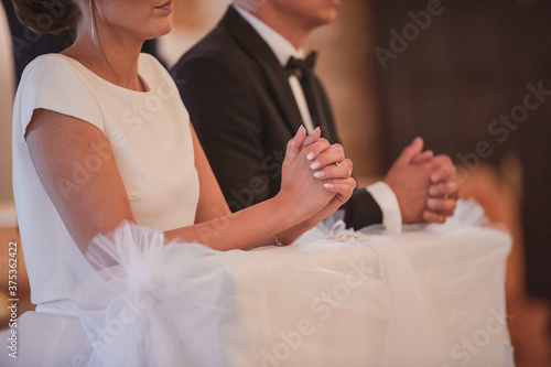 Bride and groom at church wedding during ceremony. Beautiful decoration.