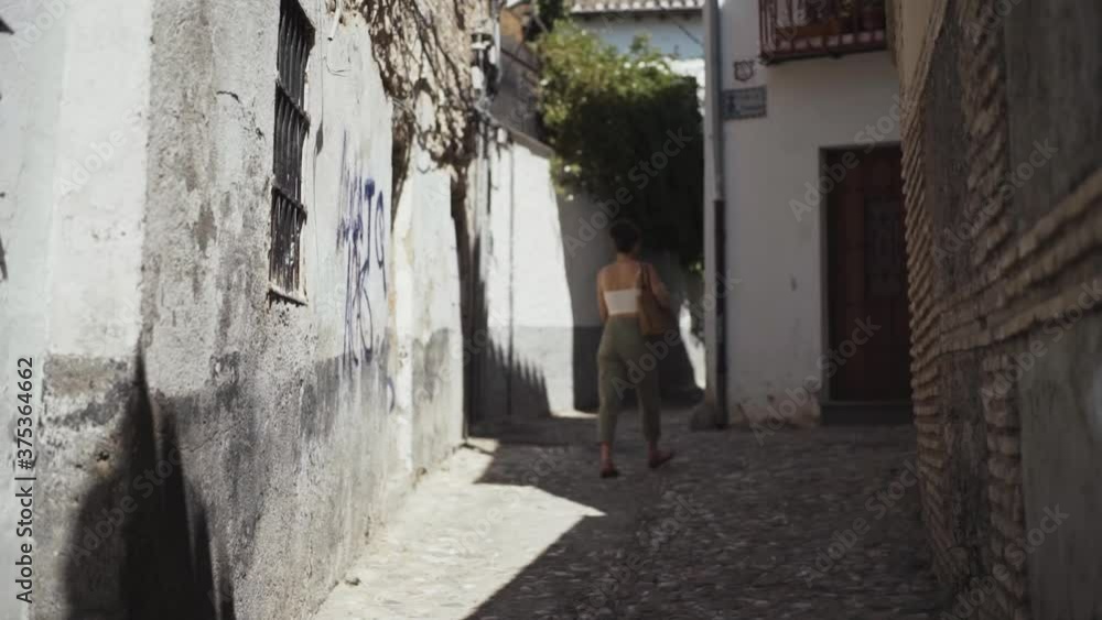 young woman walking along the streets in Granada, Spain