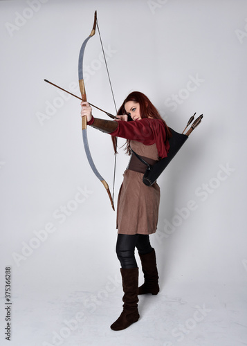Fotótapéta Full length portrait of girl with red hair wearing  brown medieval archer costume