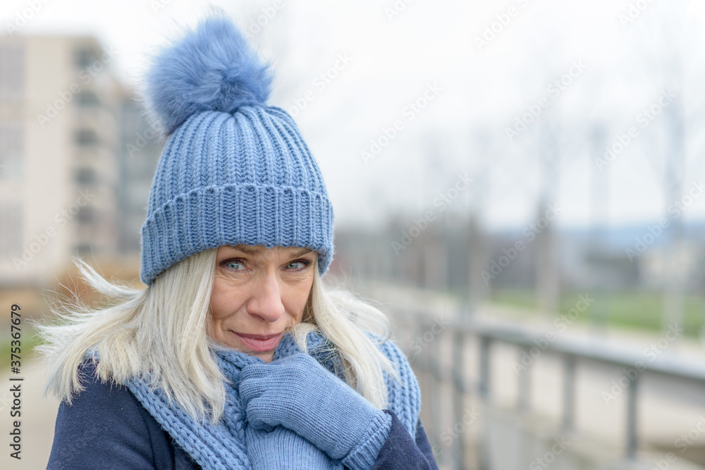 Attractive blond woman snuggling into a warm scarf Attractive blond woman snuggling into a warm scarf