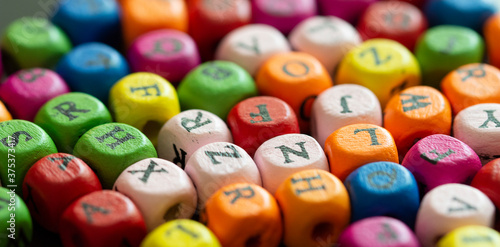 Colored cubes with letters. Multi-colored alphabet macro photography. Wooden elements of the game