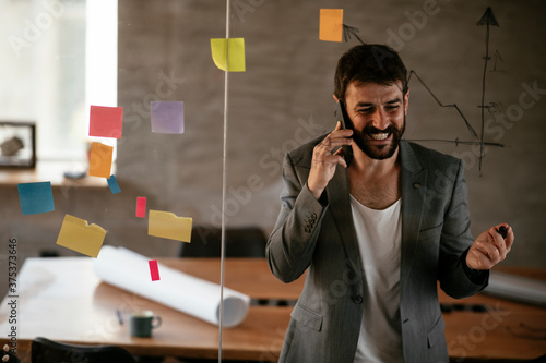Businessman working on project. Young businessman talking to the phone in the office.