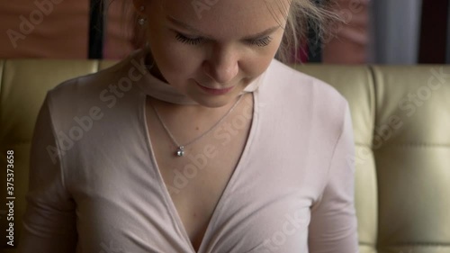 Beautiful attractive cute girl with an unusual hairstyle in a cafe is considering a menu on sushi.