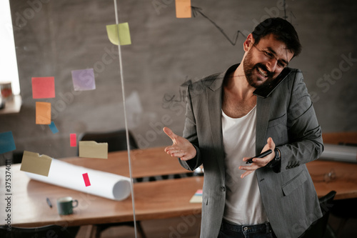 Businessman working on project. Young businessman talking to the phone in the office.