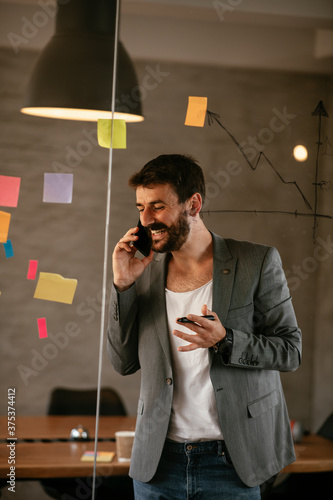 Businessman working on project. Young businessman talking to the phone in the office.