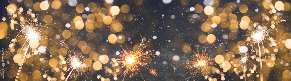 Silvester / new year background banner panorama long- Golden firework sparklers  in the dark black night with snowflakes snow and bokeh lights - obrazy, fototapety, plakaty 