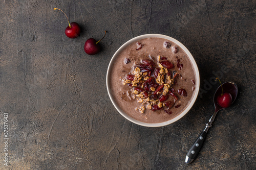 Bowl of cherry porridge oats with grated chocolate. Top view. Copy space