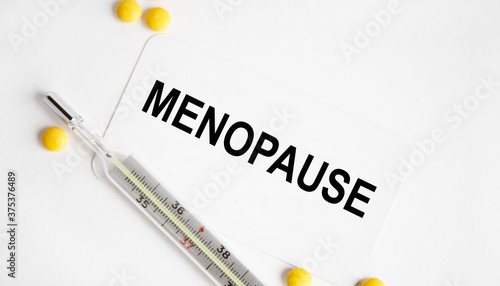 On the card is the inscription MENOPAUSE, next to the tablets.