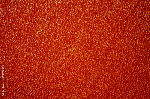 Texture of an orange plastic plate. The plate has an interesting pattern.