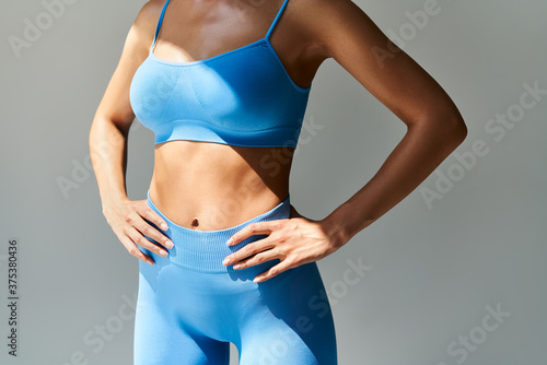Cropped image of fit woman torso  on grey background photo