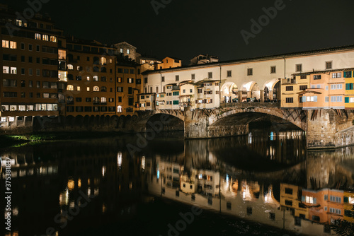 ponte vecchio florence italy by night. Lights in darkness and reflections on the water. © Pintau Studio