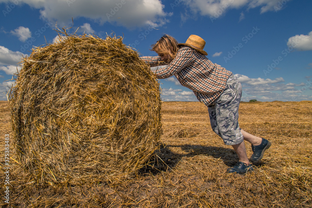 A young bearded man in cowboy hat with wheat roll A young bearded man in cowboy hat with wheat roll