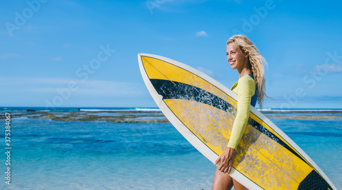 Happy woman with surfboard enjoying summer vacations