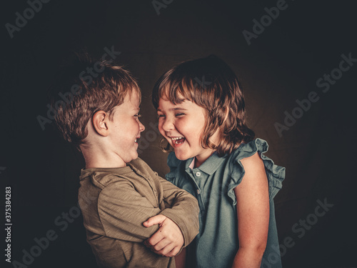 preciosos hermanos mellizos rubios divirtiendose en una sesion de fotos de estudio photo