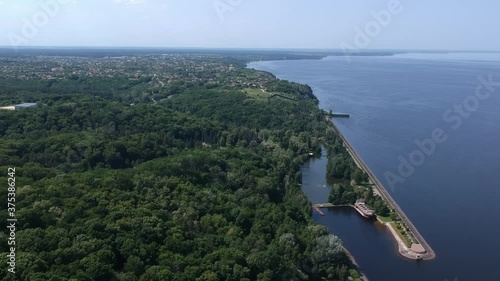 Aerial view. A large exotic wooden ship is located near the shore. Green lagoon. Kiev, Mezhyhirya. Drone