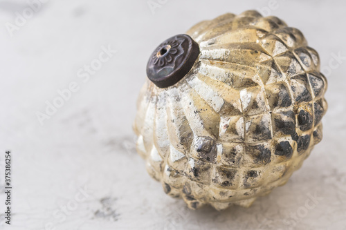 Old golden textured christmas bauble on white patterned background with copy space photo