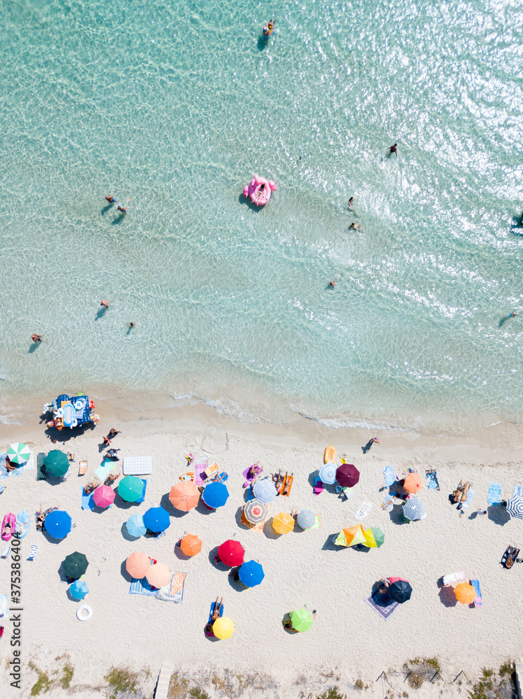 PUGLIA, ITALY - SEPTEMBER 06, 2018: Aerial view woman in bikini lie on pink flamingo in azure sea, swim, sun bathe, people relax on beach sunbeds under umbrellas, Punta Prosciutto. Summer vacation PUGLIA, ITALY - SEPTEMBER 06, 2018: Aerial view woman in bikini lie on pink flamingo in azure sea, swim, sun bathe, people relax on beach sunbeds under umbrellas, Punta Prosciutto. Summer vacation