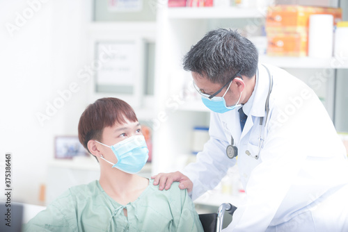 A happy male doctor is watching a young male patient in a general orthopedic clinic