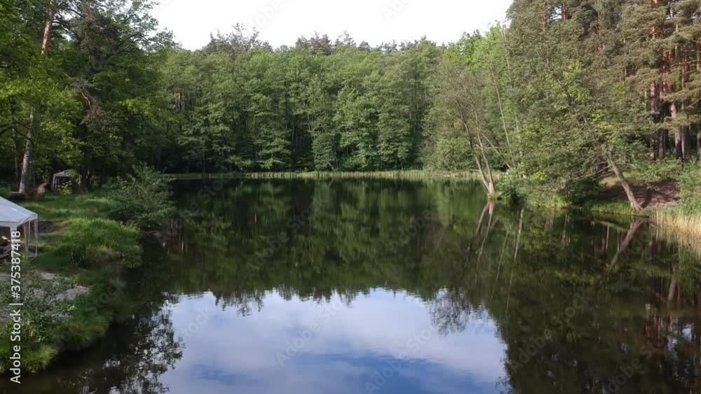 Forest lake in summer surrounded by coniferous green trees, a place to relax. View from the quadrocopter. Aerial photography. Forest lake in summer surrounded by coniferous green trees, a place to relax. View from the quadrocopter. Aerial photography.