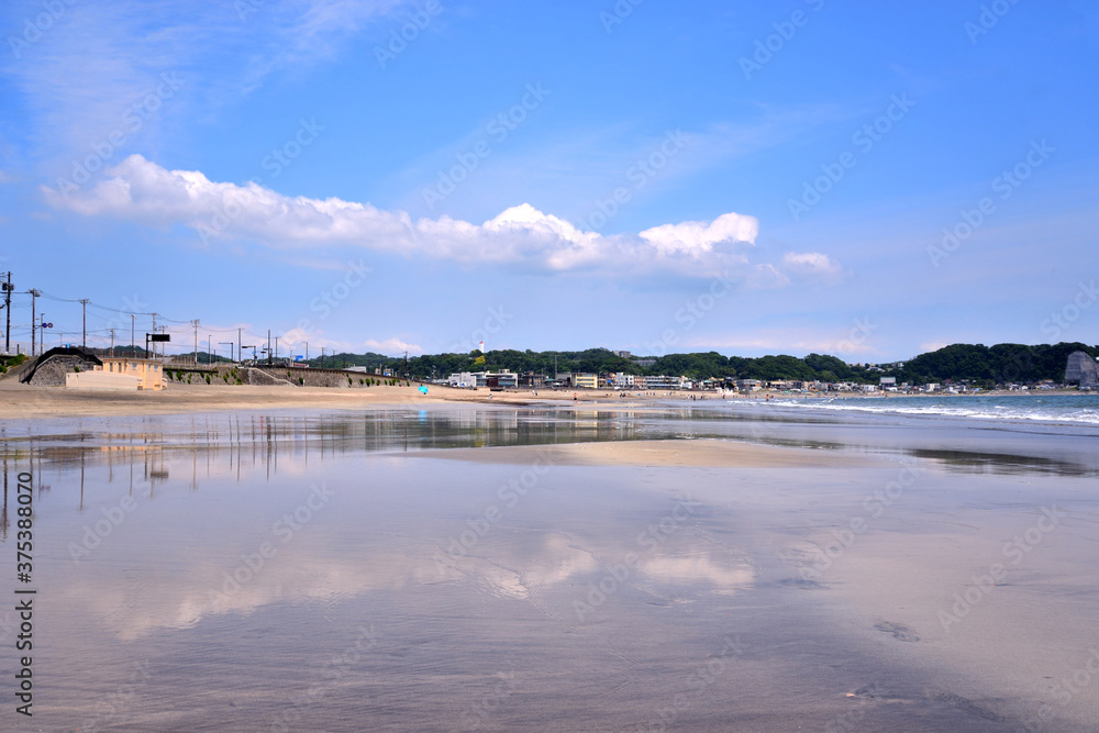 鎌倉由比ヶ浜の水辺に映り込む青空に浮かぶ白い雲