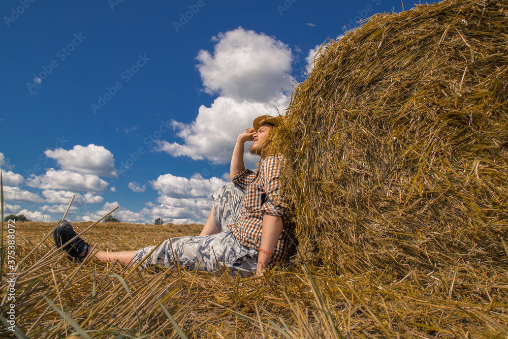 A young bearded man in cowboy hat with wheat roll A young bearded man in cowboy hat with wheat roll