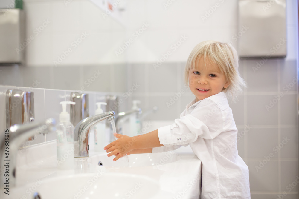 Little preschool child, blond boy, washing hands in bathroom in kindergarden - obrazy, fototapety, plakaty 