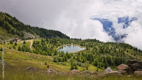 A small lake surrounded by a wood in the italian Alps near a mountain refuge (Trentino, Italy, Europe)