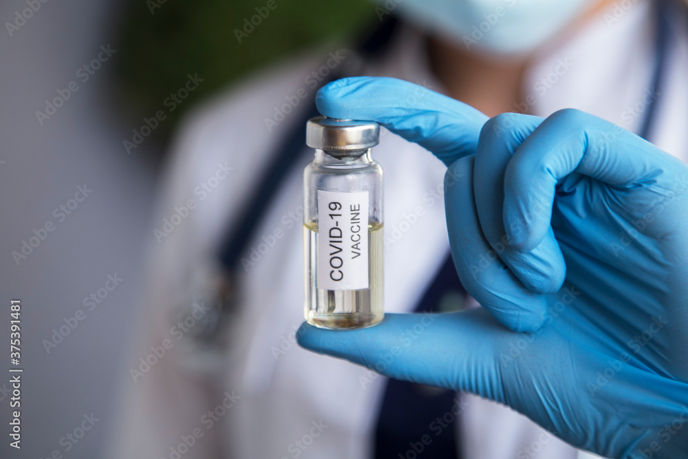 Doctor's Hand holding syringe and vaccine for vaccination in the hospital Doctor's Hand holding syringe and vaccine for vaccination in the hospital