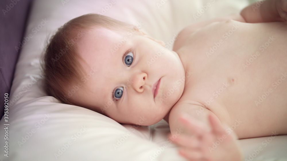 Naked baby lying on bed. Sweet child learning environment Naked baby lying on bed. Sweet child learning environment
