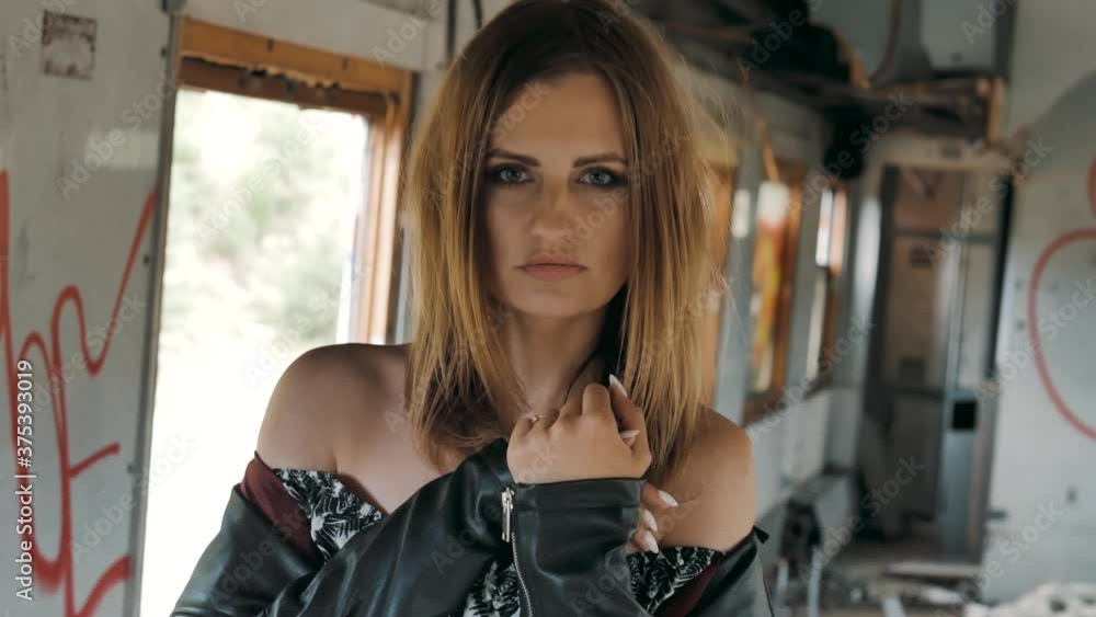 Close up portrait of Young Dark Haired female model posing in
abandoned place showing fashion. Bright makeup