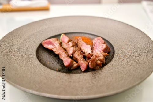 Beef tongue on black plate at Japanese restaurant in Yonezawa. photo