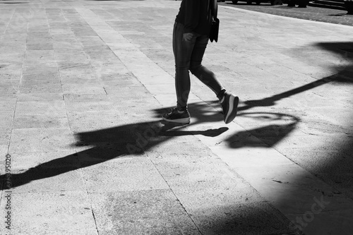 Girl walking with elongated shadow in black and white.Black and white. Shadow and light, girl silhouette
