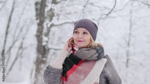 A young woman enjoys a walk in the snowy forest photo