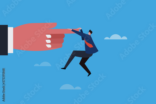 Business executive hanging on the tip of a finger of a big hand