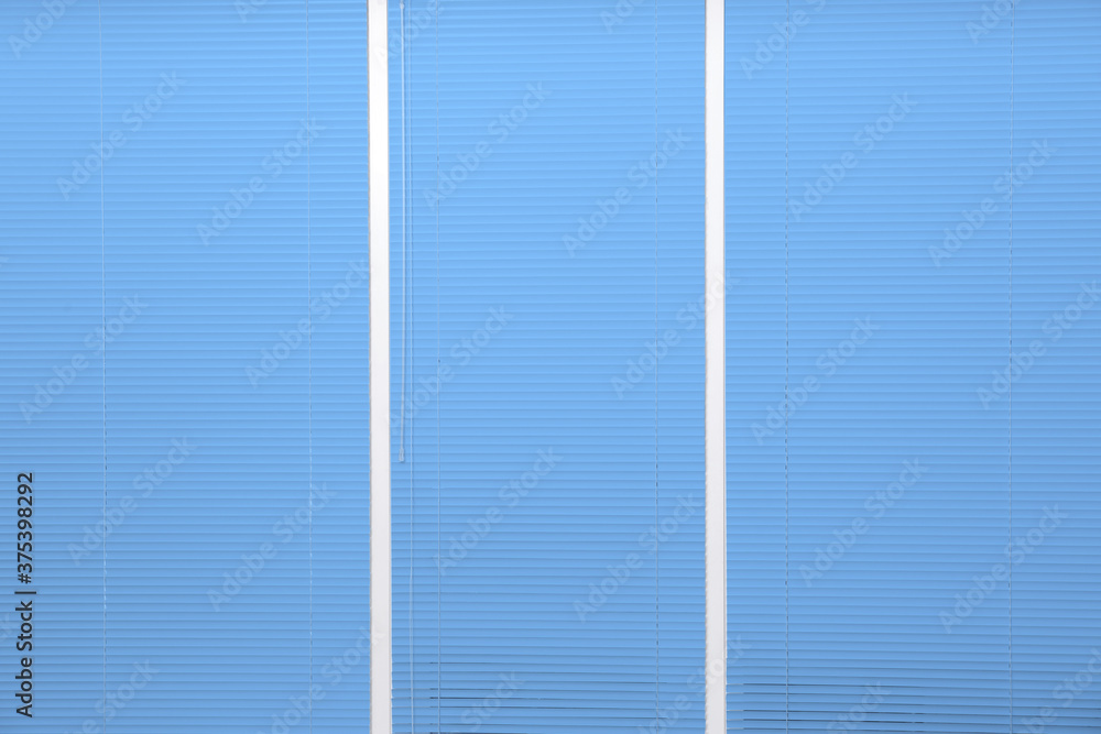 Fototapeta premium Window with closed blue horizontal blinds as background