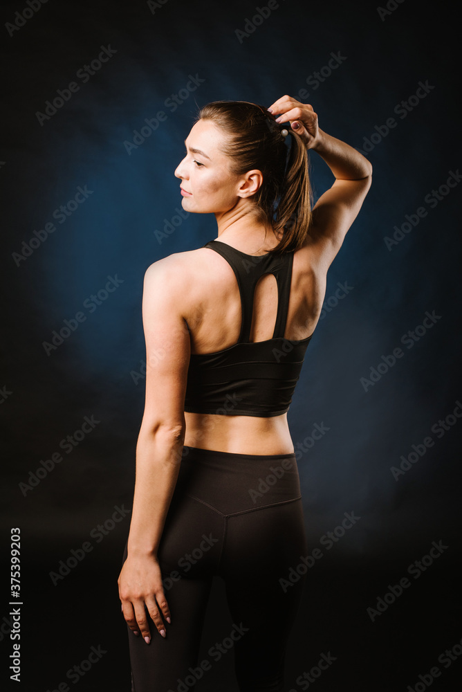 Slim sport woman doing exercises on the black studio background Slim sport woman doing exercises on the black studio background