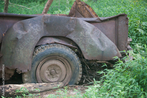 Wrecked car with rust and a tire