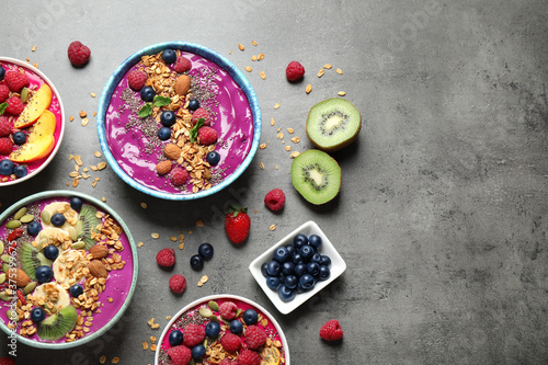 Delicious acai smoothie with toppings in bowls on table, flat lay. Space for text