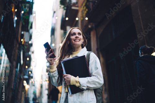 Photography Cheerful modern female student texting on street