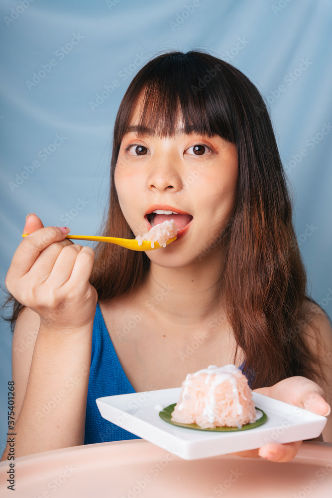 Close up of young asian woman eating sweet sticky rice with spoon. Close up of young asian woman eating sweet sticky rice with spoon.