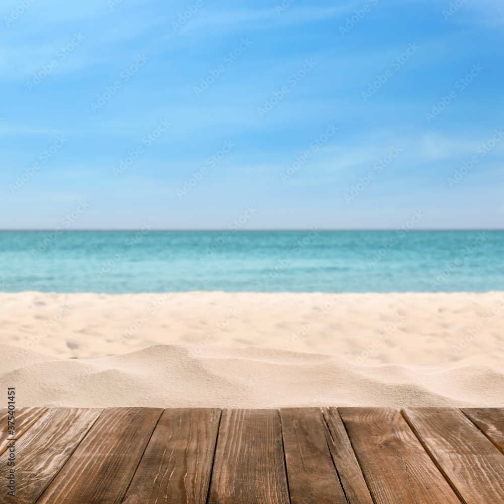 Fototapeta premium Wooden surface on sandy beach near ocean