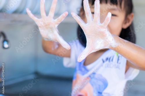 An ASEAN girl aged 3 - 4 is washing his hands.