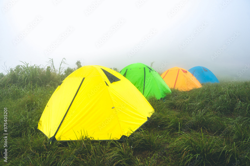 Trekking tents on green grass in the mist at Doi Suan Ya Luang, Ban San Charoen district, Nan province, Thailand
